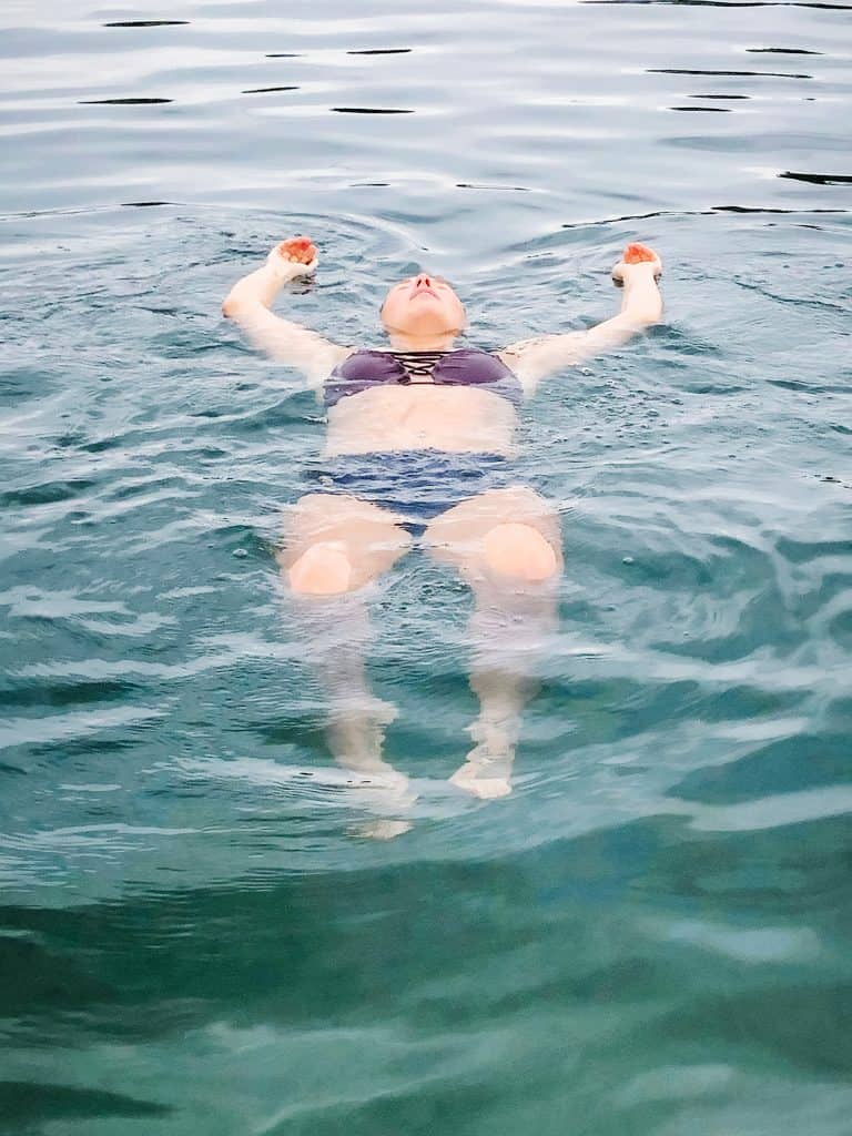 Cooling off by floating in the refreshing water. I'm relaxing on my back in a serene body of water, letting the coolness soothe me as I enjoy a moment of peace and relief from the heat of the summer.