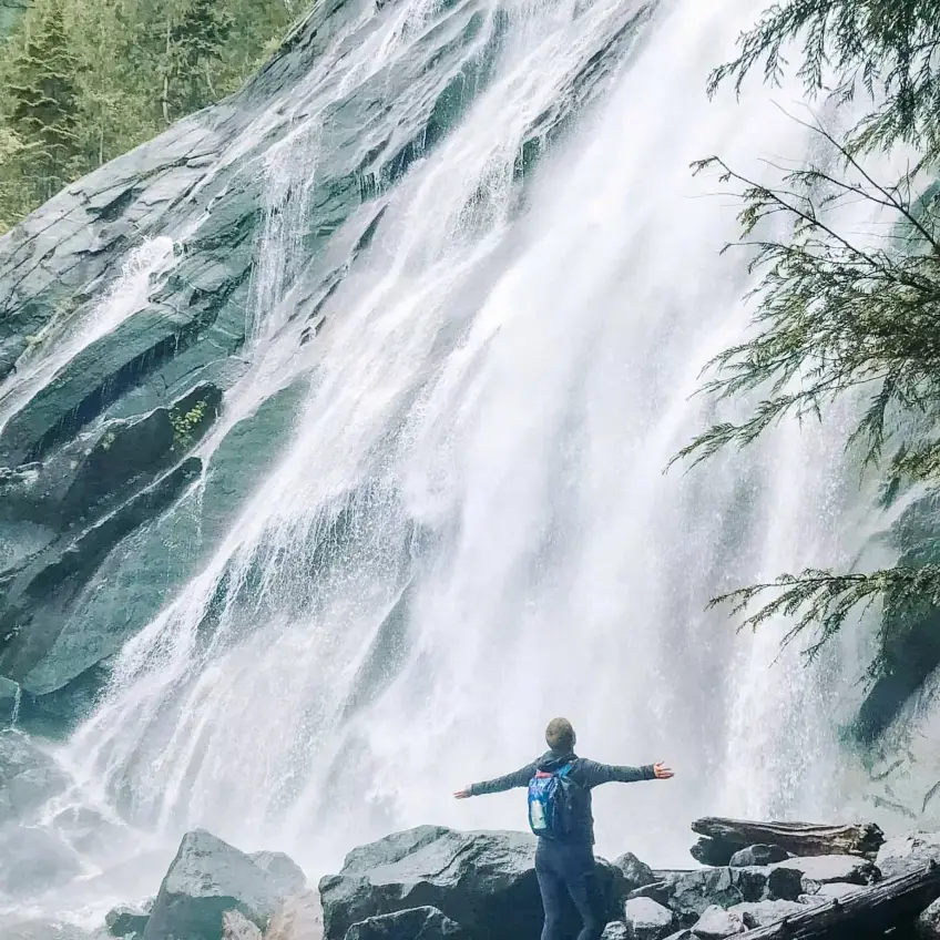 I'm standing in front of a stunning waterfall, arms outstretched in awe, feeling the cool mist on my face. Visiting breathtaking waterfalls like this one is high on my list of bucket list ideas, as it offers a sense of adventure and connection with nature's raw beauty. The powerful flow of water cascading down the rocks is both humbling and exhilarating.