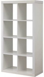 A white, rectangular shelving unit with nine square compartments, which can be used for organized storage in a camper conversion van.