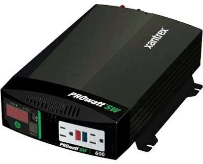 A black power inverter, an essential component for a camper conversion van, which converts DC power from batteries into AC power to run household appliances.