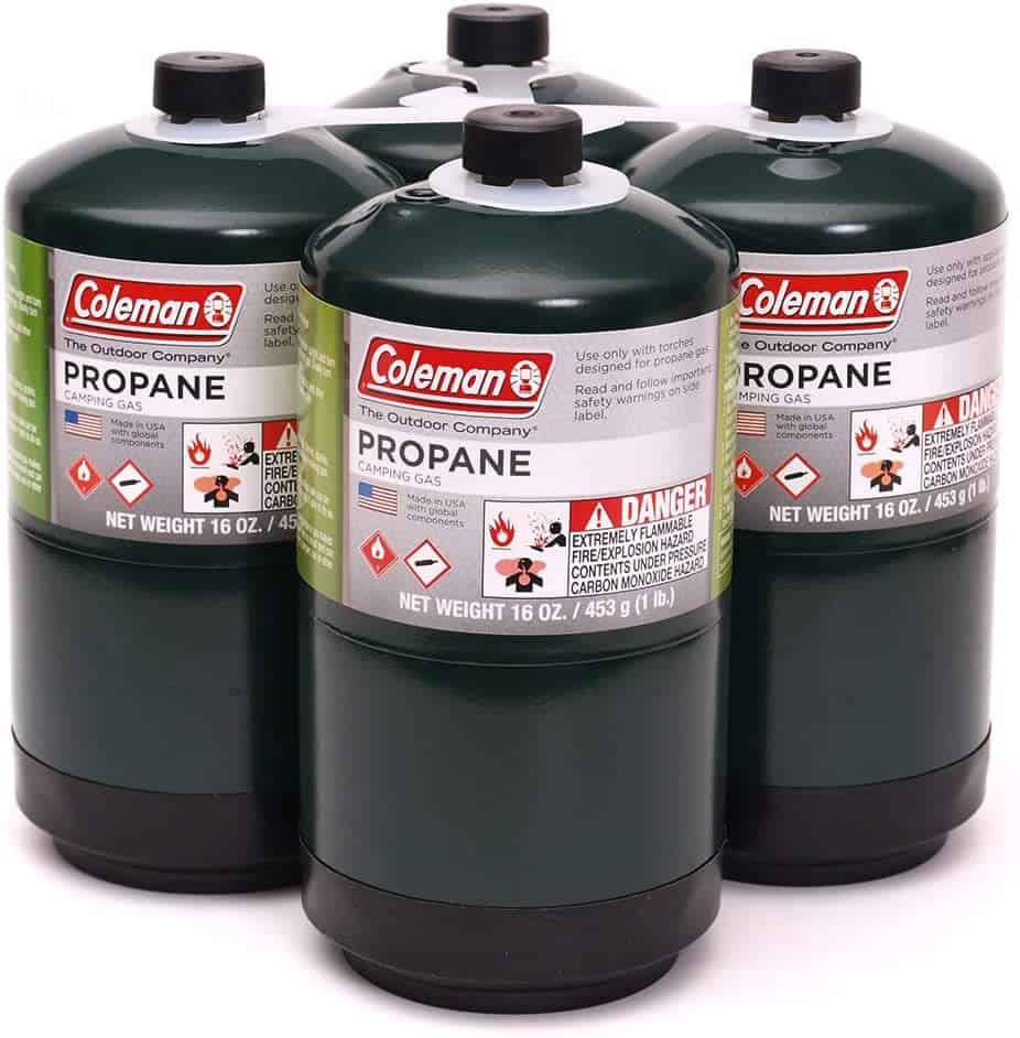 This image features four small green propane canisters, which are essential for a camper conversion van. These canisters are perfect for fueling portable stoves, heaters, and grills, ensuring you can cook and stay warm while living on the road.