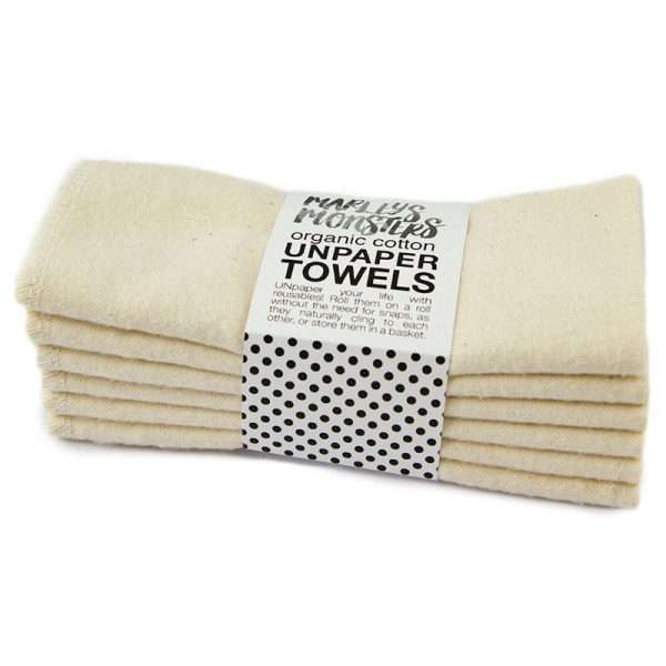 A stack of beige, reusable Unpaper Towels, neatly folded with a label wrapped around them, ideal for a camper conversion van.