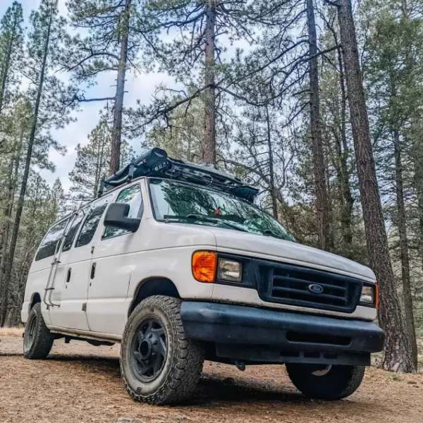 An off road camper van parked in a rugged, outdoor setting. It’s the perfect vehicle for anyone looking to explore remote places while having all the comforts of home on the road.