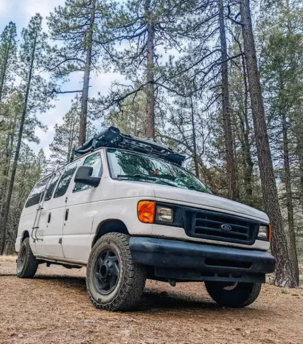 An off road camper van parked in a rugged, outdoor setting. It’s the perfect vehicle for anyone looking to explore remote places while having all the comforts of home on the road.