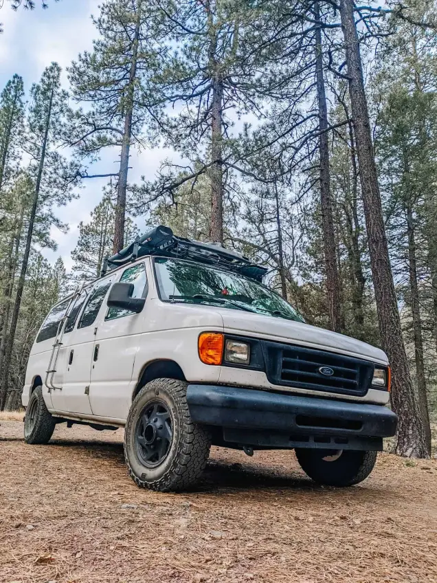 An off road camper van parked in a rugged, outdoor setting. It’s the perfect vehicle for anyone looking to explore remote places while having all the comforts of home on the road.