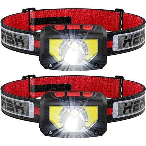 Two black and red headlamps with bright LED lights, essential for hands-free illumination on the ultimate backpacking packing list.