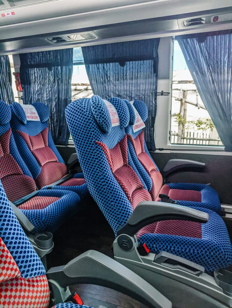 Comfortable blue and red bus seats ready for passengers, perfect for relaxing during Chichen Itza day trips.